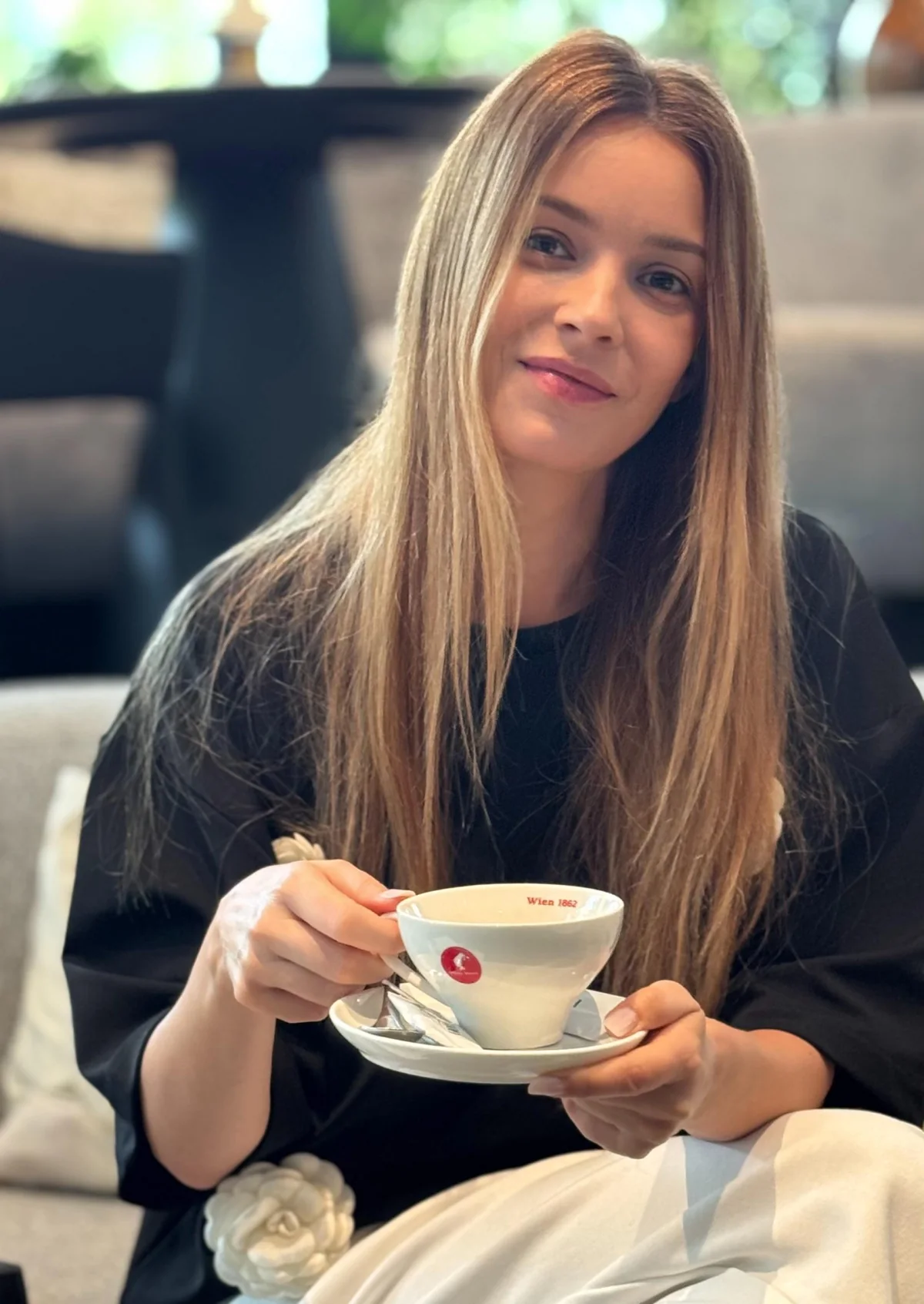 Diana Dumitrescu, zâmbind, cu o ceașcă de cafea